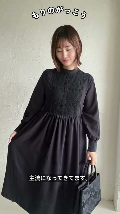 ブラックのレースワンピースの全身コーディネート。黒のハンドバッグを合わせている